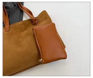Detail shot of brown faux suede tote bag featuring matching zipper pouch and leather straps