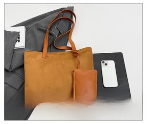 Top view of brown suede tote bag with small pouch showing interior storage capacity