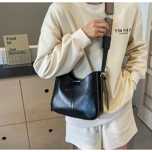 Vue détaillée du sac seau rétro noir avec une large bandoulière aux motifs ethniques