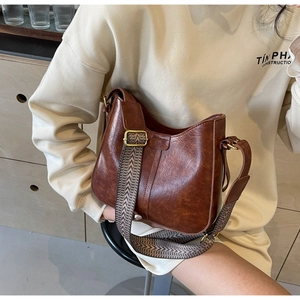 Détail du sac seau marron vintage avec large bandoulière aux motifs géométriques stylés