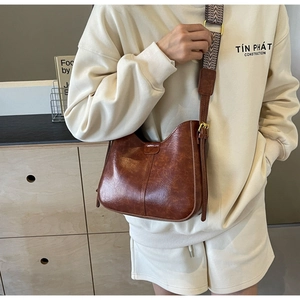 Détail du sac seau marron rétro en similicuir avec bandoulière tissée ajustable