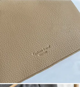 Close-up of the light brown lychee textured leather and Fashion Trend brand engraving