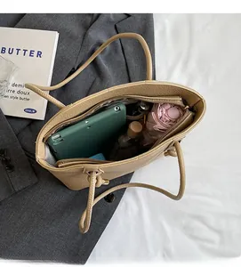 Top view of spacious bucket bag interior with compartments holding iPad and daily essentials