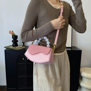Sac bandoulière rose patchwork avec poignée en perles marbrées et texture en cuir