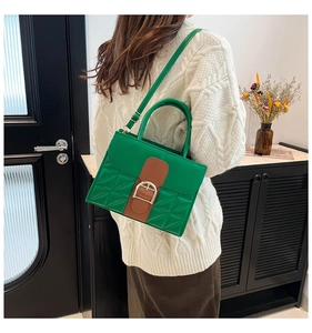 Détail du sac bandoulière bicolore avec matelassage géométrique et boucle fer à cheval