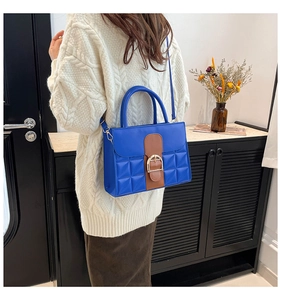 Blaue gesteppte Leder-Quadrat-Tasche mit Goldschnalle am Körper für den Alltag getragen