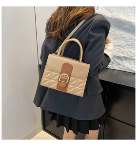 Detail der gesteppten Handtasche aus Leder mit goldener Schließe in Beige und Braun