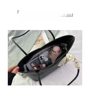 Spacious black textured leather tote bag interior view with silk scarf and daily essentials