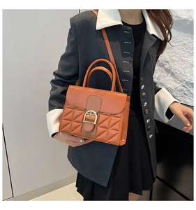 Détail du sac à main motif crocodile caramel avec boucle fer à cheval dorée et coutures