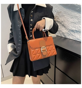 Détail du sac bandoulière rétro orange avec motif matelassé et boucle mors dorée