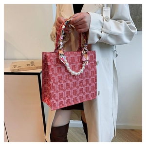Detail van rode tote bag met dubbel geluk jacquard en zijden sjaal handvat