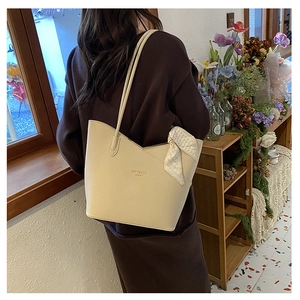 Detail of cream crossbody tote with lychee texture and geometric pattern silk scarf