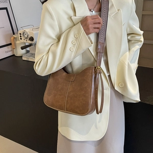 Sac hobo vintage marron avec large bandoulière géométrique porté par un mannequin