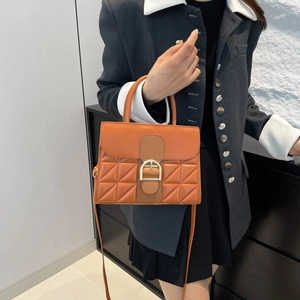 Schicke orangefarbene Stepptasche mit goldener Schnalle und glattem Lederfinish