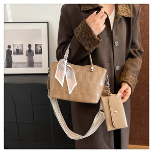 Dettaglio della borsa scozzese con tracolla jacquard e foulard in seta su borsa kaki