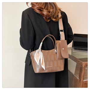 Dettaglio borsa a quadri marrone con tracolla jacquard, mini pochette e sciarpa di seta