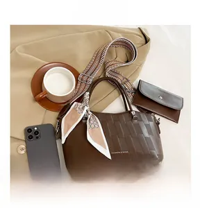 Vista dettagliata della borsa tote a quadri con tracolla larga, pochette e foulard decorativo
