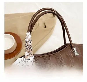 Dettaglio borsa tote in pelle marrone con foulard a scacchi e fiocco in metallo argento
