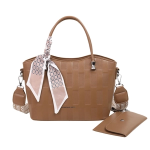 Set borsa a mano marrone intrecciata con tracolla fantasia e foulard su sfondo bianco