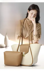 Détail du grand sac cabas bicolore crème et marron avec fermoir doré et pochette assortie