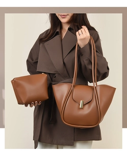 Détail du sac fourre-tout caramel avec boucle dorée sur un trench-coat marron élégant
