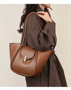 Vue détaillée du sac cabas en cuir marron avec plis latéraux et boucle dorée en métal