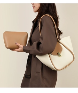 Vue détaillée du sac cabas crème et marron avec boucle en métal porté sur un manteau