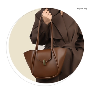 Détail du sac cabas en cuir marron foncé avec un fermoir doré rectangulaire sur le rabat