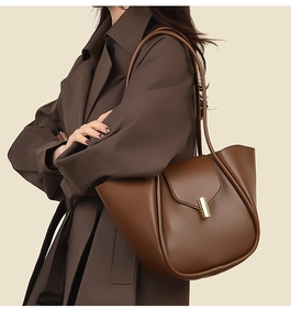 Détail d'un sac cabas en cuir marron avec boucle dorée élégante et bandoulière