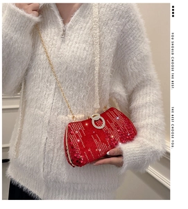 Detailed view of red sequin evening clutch with crystal lock and golden chain strap