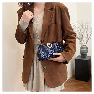 Blue sequin evening bag with gold chain strap and diamond buckle on model outfit