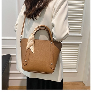 Détail du sac seau marron à grain de litchi avec foulard en soie à imprimé cœurs