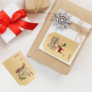 Christmas kraft paper gift tags with festive reindeer designs on decorated brown gift boxes