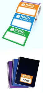 Colorful 'Hello my name is' sticker labels on roll and applied to a notebook