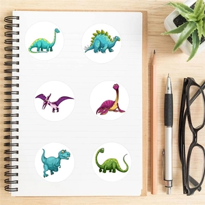 Cartoon dinosaur reward stickers set for kids notebooks on a wooden desk with stationery