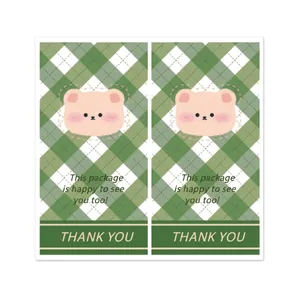 Green plaid rectangular bear stickers with 'This package is happy to see you' text