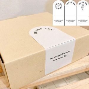 Detail of white rectangle thank you stickers on kraft boxes for gift packaging
