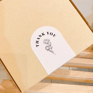 White arch adhesive labels with rose design and Thank You text on brown box