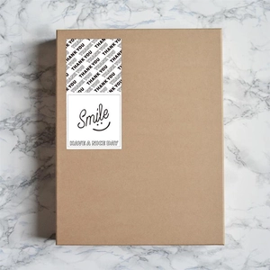 Detail of rectangular black and white smile and thank you stickers on kraft gift box