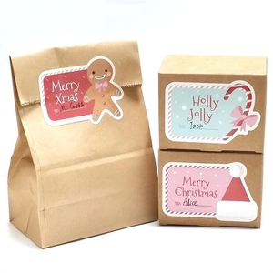 Détail macro d'autocollants de Noël sur sacs en papier kraft avec étiquettes de nom et texte
