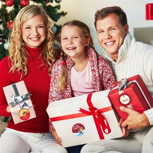 Family holding gifts with Merry Christmas stickers during holiday celebration