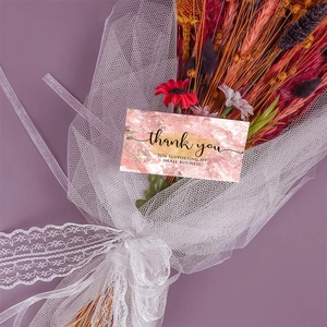 Pink marble thank you card on dried flowers and purple backdrop with delicate lace