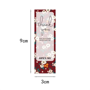 Detail view of floral Thank You seal sticker measuring 9x3cm for gift box packaging