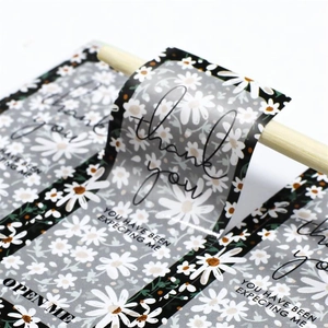 Macro detail of waterproof floral thank you stickers on roll with daisy pattern and text