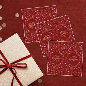 Close-up of Merry Christmas rectangular labels with gold foil stamping on red paper