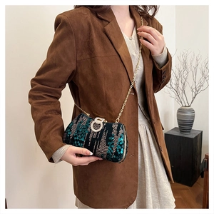 Detail of dark green sequin clutch with gold rhinestone ring buckle and chain strap