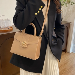 Sac à main kaki élégant avec fermoir fleur dorée présenté dans un décor chic