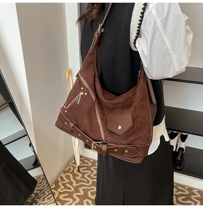 Detail of vintage brown suede tote bag featuring metallic zippers and motorcycle style