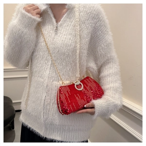 Sparkly red sequin evening bag with gold chain and diamond lock on a white sweater