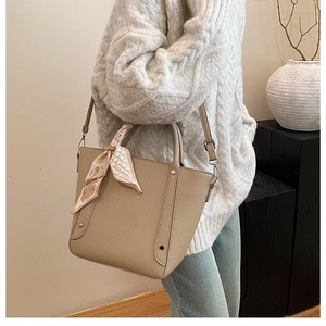 Vue détaillée du sac seau en cuir kaki avec foulard décoratif et bandoulière amovible